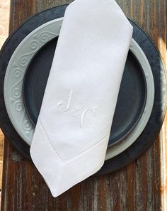 a white napkin sitting on top of a plate next to a black and gray plate