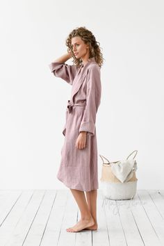 "Wrap yourself in soft, airy, pure linen bath robe. This linen bathrobe is the perfect gift for woman or can be used as a bridal robe. Made from luxurious, softened linen, this dressing gown absorbs water very well and dries quickly. Designed to have a loose fit, it can be cinched at the waist with a tie. Long sleeves can be rolled up to form ¾ sleeves. Please note that due to the many variations in monitors and browsers, actual colors may vary. Our bath robe is available in woodrose, gray blue, Elegant Summer Dresses For Relaxation, Chic Wrap Dresses For Loungewear, Elegant Spring Home Robe, Chic Linen Lounge Dress, Chic Summer Sleep Robe, Elegant Spring Dresses For Relaxation, Elegant Summer Robe For Relaxation, Feminine Long Sleeve Home Robe, Feminine Long Sleeve Robe For Home