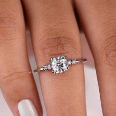 a woman's hand with a ring on it and a diamond in the middle