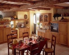 a kitchen with yellow walls and wooden furniture in the center, along with a dining table set for four