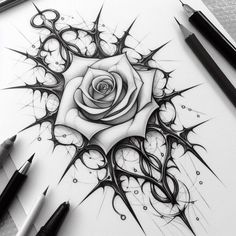 a drawing of a rose on paper with some sharp scissors and ink pens next to it