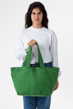 a woman holding a green tote bag