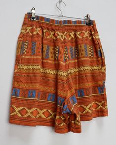 "a vintage orange and blue geometric patterned shorts ✿ IMPORTANT INFORMATION: * excellent vintage condition * size: small - please check exact measurements below (they're there for your benefit!) * hip pockets ✿ MEASUREMENTS (taken while item is lying flat, some measurements will need to be doubled): * waist: 12-15\" (30-38cm) - elasticated * hips: 22\" (56cm) * front rise: 13.5\" (34cm) * back rise: 16\" (41cm) * leg in-seam: 4\" (10cm) * leg out-seam: 16\" (41cm) * thigh width: 13.5\" (34cm) Vintage Brown Cotton Shorts, Brown Bohemian Shorts, High-waisted Orange Shorts For Vacation, Multicolor Bottoms With Geometric Pattern For Summer, Vintage Bermuda Bottoms With Built-in Shorts, Vintage Multicolor Short Bottoms, Vintage Multicolor Short Length Bottoms, Retro Orange Bottoms With Pockets, Vintage Style Vacation Bottoms Short Length