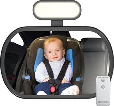 a baby sitting in a car seat next to a remote control