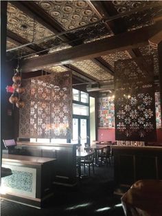 the interior of a restaurant with many tables and chairs in front of large wall panels