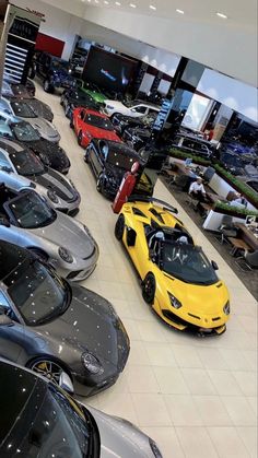 there are many cars parked in the showroom