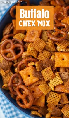 a blue bowl filled with chex mix on top of a checkered table cloth