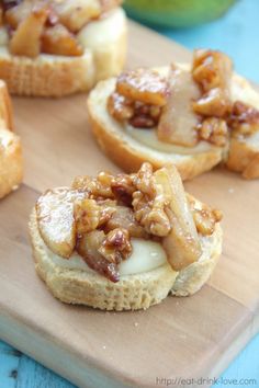 mini pecan and pine crostini on a cutting board next to an apple