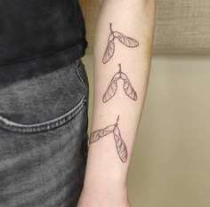 a woman's arm with three small leaves on the left side of her arm