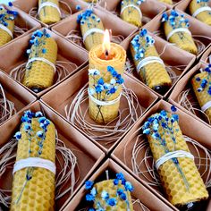 a box filled with lots of yellow and blue items next to a candle on top of a table