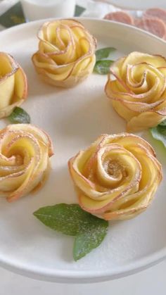 small yellow roses on a white plate with green leaves