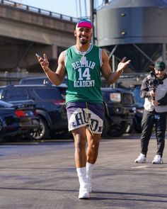 a man in green shirt and shorts running on street