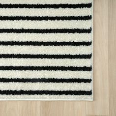 a black and white striped rug is on the floor next to a wood flooring