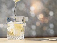 a glass filled with liquid on top of a wooden table