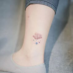 a small cloud tattoo on the ankle