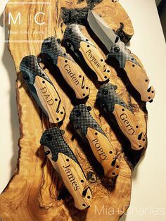 there are many knives that are on the wooden board with black and white designs around them