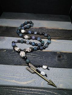 This is a beautiful re-imagined rosary based on the classic Catholic rosary. The beads are matte finish fancy jasper and the spacing beads howlite skulls. There are three decades of nine beads each. The center is a large howlite skull, and I have capped it off with Artemis's arrow and hematite and howlite dangles. With this rosary I'm including a simple chant which has resonated with me, but feel free to use your own! Pagan/witch prayer chant: Knot one, the work's begun. Knot two, my aim is true Spiritual Gemstone Beads Rosary, Spiritual Rosary With 8mm Beads, Spiritual Rosary With 8mm Beads For Healing, Spiritual Beaded Rosary For Jewelry Making, Spiritual Festival Agate Beaded Necklaces, Spiritual Agate Beaded Necklaces For Festival, Spiritual Natural Stone Beads For Festivals, Bohemian Hand-strung Healing Rosary, Bohemian Beaded Rosary For Healing