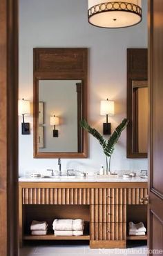 a bathroom with two sinks, mirrors and lights on the wall next to each other