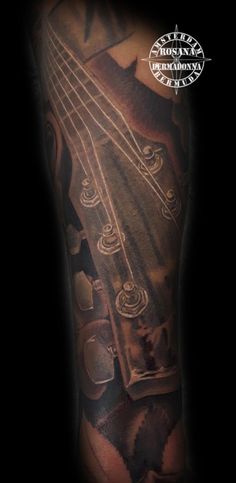 a man with a guitar tattoo on his arm