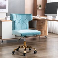 a green office chair sitting in front of a desk with a computer monitor on it