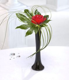 a black vase with a red rose in it and the words vase included above it