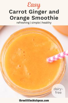 carrot ginger and orange smoothie in a mason jar with a pink striped straw on top