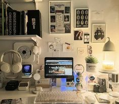 a desktop computer sitting on top of a desk next to a lamp and pictures above it