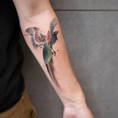 a man with a bird tattoo on his arm