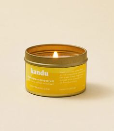 a candle that is sitting in a tin on a white surface with the words landu written below it