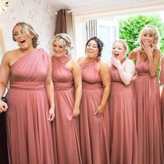 a group of women standing next to each other in front of a mirror with their mouths open