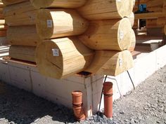 several stacks of wooden logs stacked on top of each other in front of a building