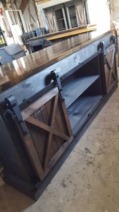 a kitchen island made out of wood and metal with sliding doors on the front door