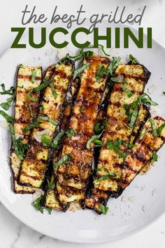 grilled zucchini on a white plate with herbs