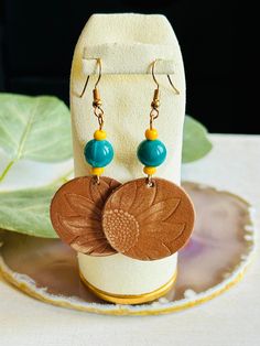 These adorable leather sunflower earrings are hand made in the USA.  Add a little bit of fun to your wardrobe ladies!  These earrings are the perfect accessory for a night out on the town or with a pair of your favorite jeans.  This earring is a great gift for any woman.  The earring is length 2" Due to the assorted nature of this item, unique variations in color and print yield one-of-a-kind pendants. The pendant you receive may vary in style, print, and color from what is pictured. Adjustable Nickel-free Flower Earrings For Everyday, Adjustable Sunflower Design Earrings For Summer, Yellow Leather Jewelry For Gifts, Hand Tooled Adjustable Dangle Earrings, Everyday Adjustable Dangle Flower Earrings, Trendy Leather Earrings As Gift, Leather Sunflower, Sunflower Pendant, Sunflower Earrings