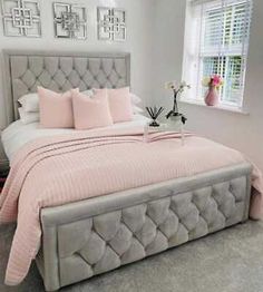 a bed with pink sheets and pillows in a bedroom