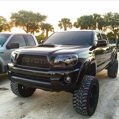 a black toyota truck parked next to other trucks