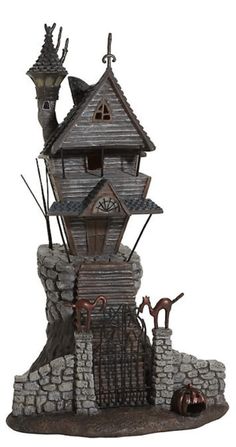 a statue of a house on top of a rock wall