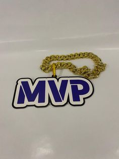 a blue and white logo with a gold chain hanging from it's center piece