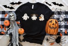 a black t - shirt with boo on it next to pumpkins and other decorations