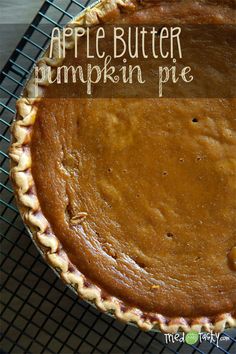 an apple butter pumpkin pie on a cooling rack with the words, apple butter pumpkin pie