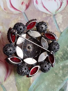 This is a vintage red, glass rhinestone and steel cut brooch. My best guess is that this is from the 1940s. I think it may be older however. It is really a stunning piece. The brooch measures about 2 inches across. Don't forget to stop in at my other Etsy shop... http://www.etsy.com/shop/xtdesigns. Follow me on Twitter at... MyYiayiaHadThat@MyYiayiaHadThat. If you have a wish list or are looking for something specific, please ask. I may have exactly what you are looking for. As always please con Vintage Red Pins For Gifts, Vintage Red Pins For Party, Vintage Red Pins For Gift, Vintage Red Pins As Gift, Red Retro Brooch Jewelry, Vintage Red Jewelry With Rhinestones, Retro Red Brooch Jewelry, Vintage Red Brooches For Formal Occasions, Vintage Red Brooches For Party