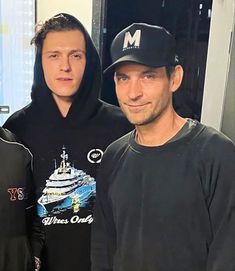 three men standing next to each other in front of a mirror