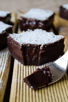 some brownies with powdered sugar on them and a spoon