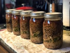 four jars filled with food sitting on top of a counter