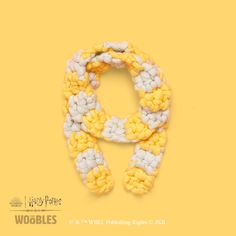 a yellow and white knitted scarf on top of a yellow background with the words woolies written below it