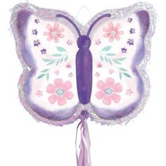 a purple and white butterfly shaped balloon with pink flowers on it's wings, tied to a string