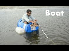 a man sitting on top of a blue barrel in the water