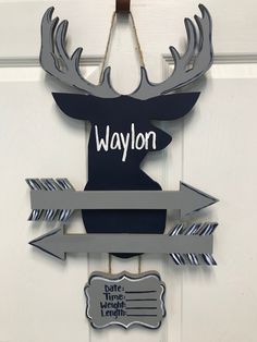 a door hanger with a moose head and name tag hanging from it's side