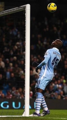 a soccer player in the air with his head above the net as he heads for the ball