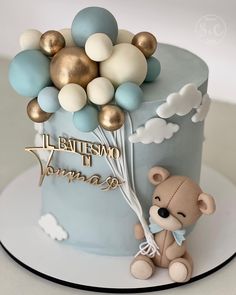 a birthday cake with a teddy bear and balloons